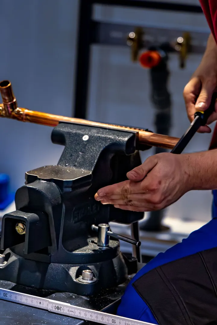 Plumber bending copper pipe for a water heater connection, water heater installation Fort Myers