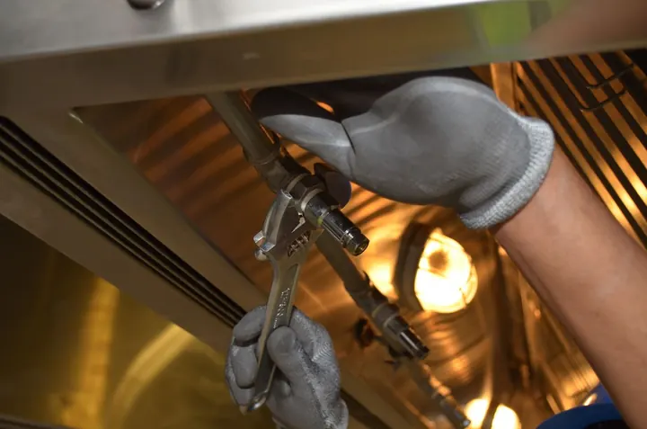 Technician tightening a pipe fitting, water heater installation Fort Myers