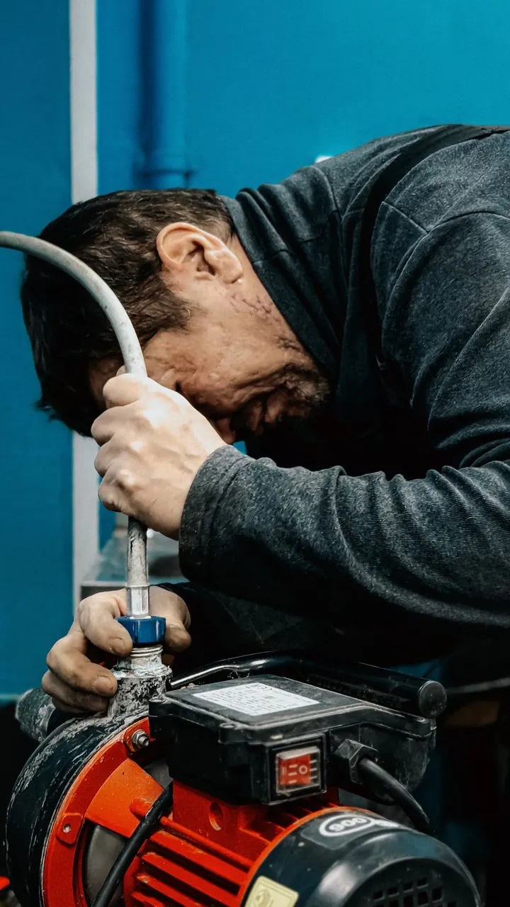 Technician adjusting a water pump, water heater installation Fort Myers